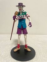 Front view of Joker figure with accessories on stand