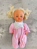 Front view of blonde baby doll in pink fleece romper