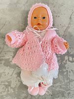 Front view of vinyl baby doll in full knit outfit