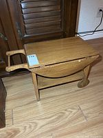 Full view of child-size wooden tea wagon showing top, wheels, handle