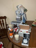 Overview of lot on table showing Santa figure, candles, ornaments, ceramic jars
