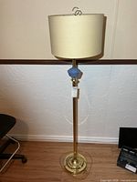 Full view of brass floor lamp with shade