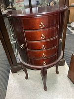 Front view of demi-lune jewelry chest showing drawers and legs