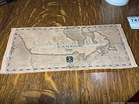 Front of cardboard sleeve showing ‘Millennium Canada 1999’ map design