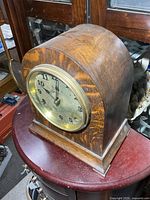 Front view of oak mantle clock showing dial and bezel