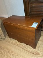 Front and side view of wooden storage bench showing overall form and finish