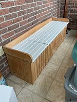 Front view of storage bench showing beadboard sides and white slat top