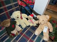 Group of four teddy bears on plaid chair