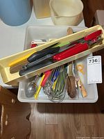 Tray and bin filled with assorted utensils