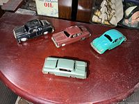 Four vintage metal friction cars on table
