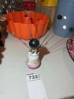 Front view of porcelain holder with visible chip and mounted hat pins