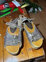 top view of both sandals showing leather uppers, buckles, stitching and wooden platforms