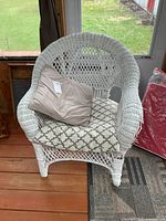 front view of white wicker armchair with cushions