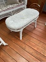 Full view of white wicker coffee table on wood floor