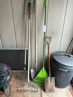 All five yard tools standing against wall