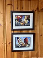 Both framed sailboat prints mounted on wall