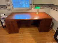 Front angled view of entire desk showing top, drawers, finish