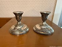 Front view of both sterling candle holders on table