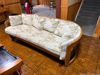 Full view of sofa angled, showing curved wood frame, cushions, and upholstery pattern