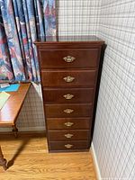 Front view of tall 7-drawer chest against wall