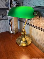 Front view of brass base banker's lamp with green glass shade