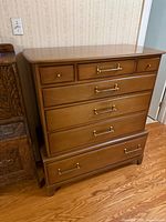 Front view of dresser showing all seven drawers and brass handles