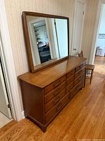 Angled hallway view of dresser with mirror showing side profile and top