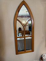 Full view of wooden arch mirror on wall