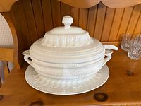 Front view showing tureen, lid, underplate, handles, embossed pattern