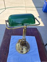 Full view of lamp from above showing green shade, brass base, pull chain, cord