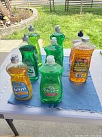 All eight cleaner bottles on table showing brands and colors