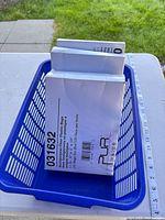 Three PUR Value boxes in blue plastic basket on table with ruler