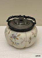 Front view of melon-shaped enamelled glass jar with silver-plate lid and handle