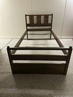 Full view of twin bed frame from foot showing headboard, side rails, stabilizers