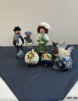 Group view of wooden carolers, ornaments, candles and tablecloth