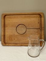 Carving board front side with groove and well, glass pitcher set in front