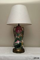 Full view of lamp with shade on showing ceramic body and base