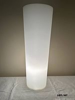 Front view of tall frosted glass lamp illuminated