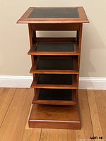 Front view showing wood frame, four shelves, leather inlays, base