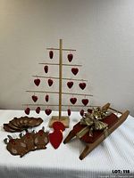 Group shot showing tree with hanging hearts, turkey holders stack, turkey head, sled