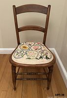 Front view of cherry side chair showing embroidered seat and turned legs