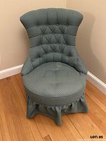 front view showing diamond-tufted back, round seat, skirt, wood rocker ends