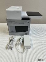 Printer assembled on top of box with cords in foreground
