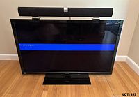 Front view of Toshiba TV on stand with Vizio soundbar resting on brackets, screen powered displaying "No video signal"