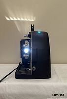 Left side view of projector powered on showing lit lamp and film path components