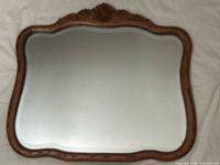 Front view of oak-framed mirror showing overall shape and crest