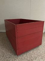 Angled side view showing red wooden box exterior