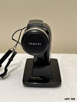 Front view of Xacti camcorder seated on HDMI docking station with wrist strap