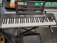 Casio keyboard on X-stand with stool visible