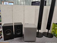 Full lot view showing two bookshelf speakers, subwoofer, two Sony towers